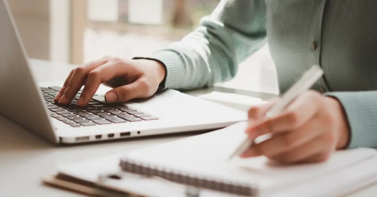 Cropped image of an Assistant budgeting for an upcoming in-person meeting on a notebook while on her laptop