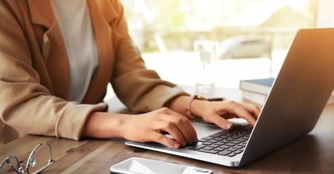 Cropped image of an assistant working on her laptop at her desk