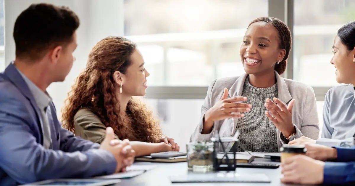 Discussion in a conference room around a table between Human Resources and Executive Assistants on in-person meetings