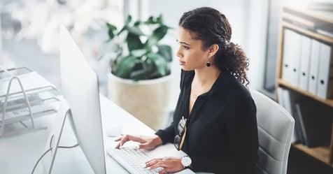 Executive Assistant creating a plan on her computer to address scope creep