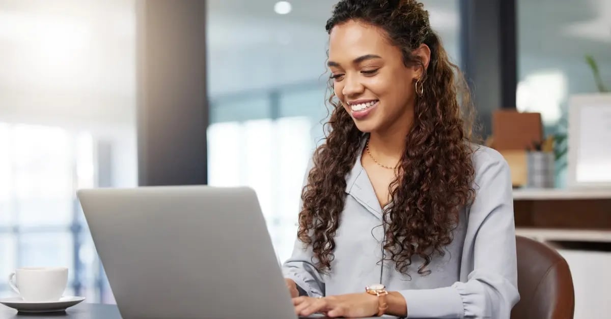 Executive Assistant planning an in-person meeting on her laptop in the office