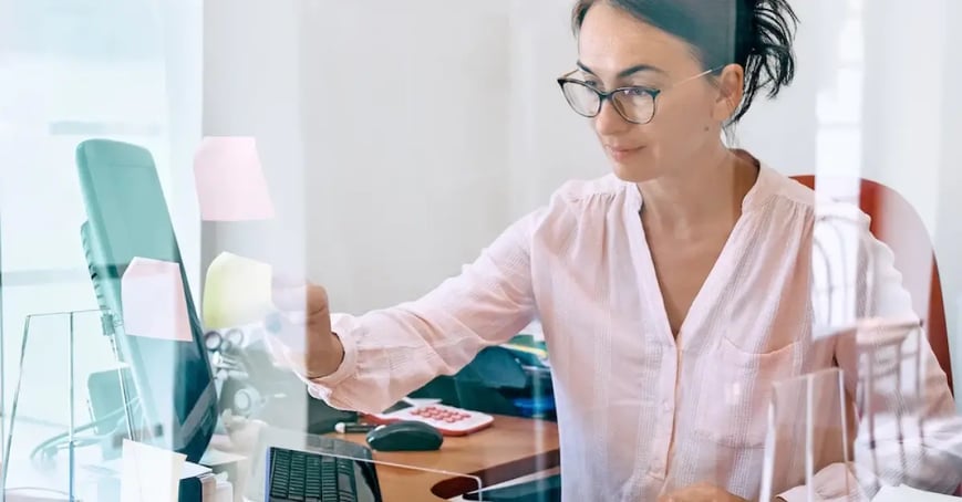 Executive Assistant working at her desk creating an attendee experience for an upcoming meeting