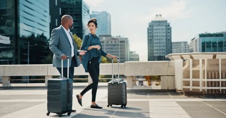 Executive Assistants with suitcases outside walking to a meeting venue in an off the beaten path city