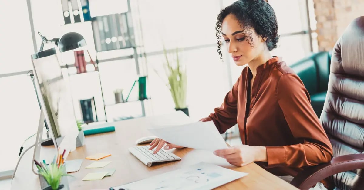 Female Executive Assistant sitting at her desk working with a comfortable desk setup