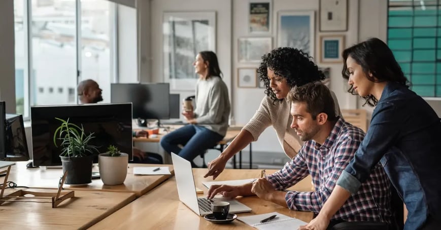 Group of meeting planners in front of a laptop figuring out procurement