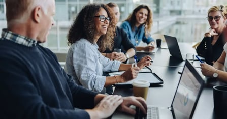 In-person meeting with a team sitting around a table in a conference room