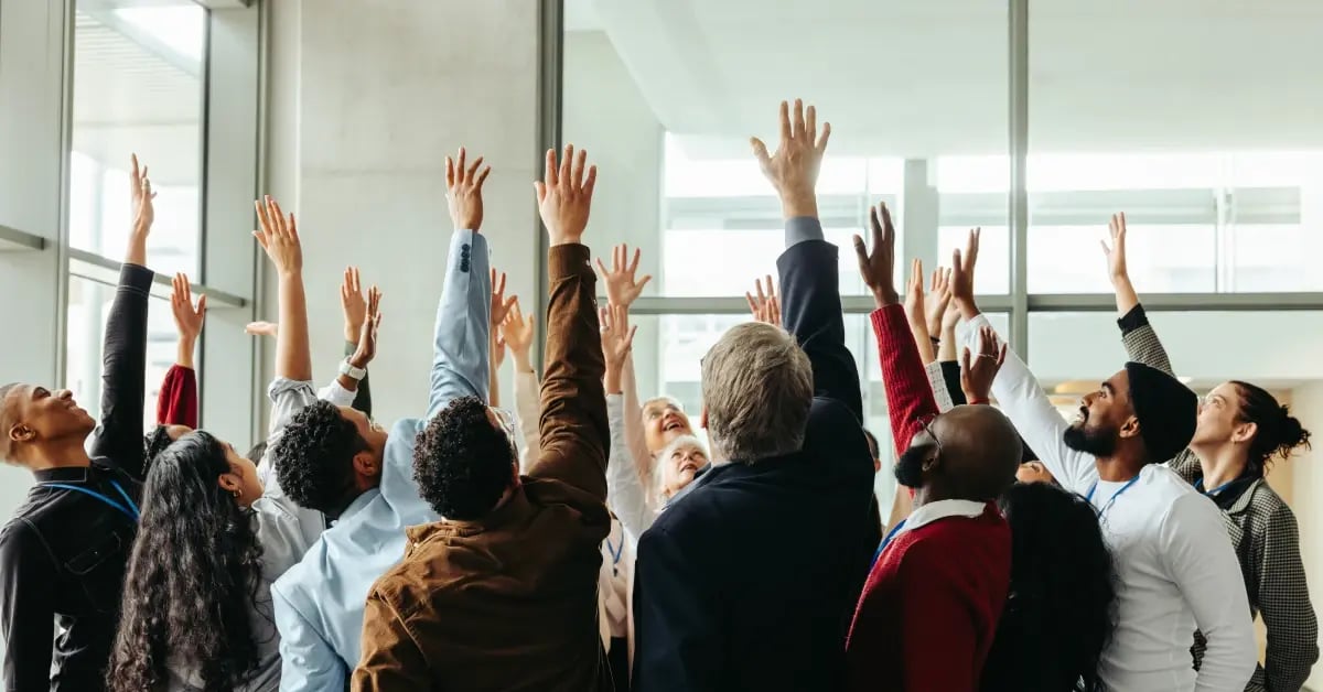 Team activity with everyones arms and hands raised in the air