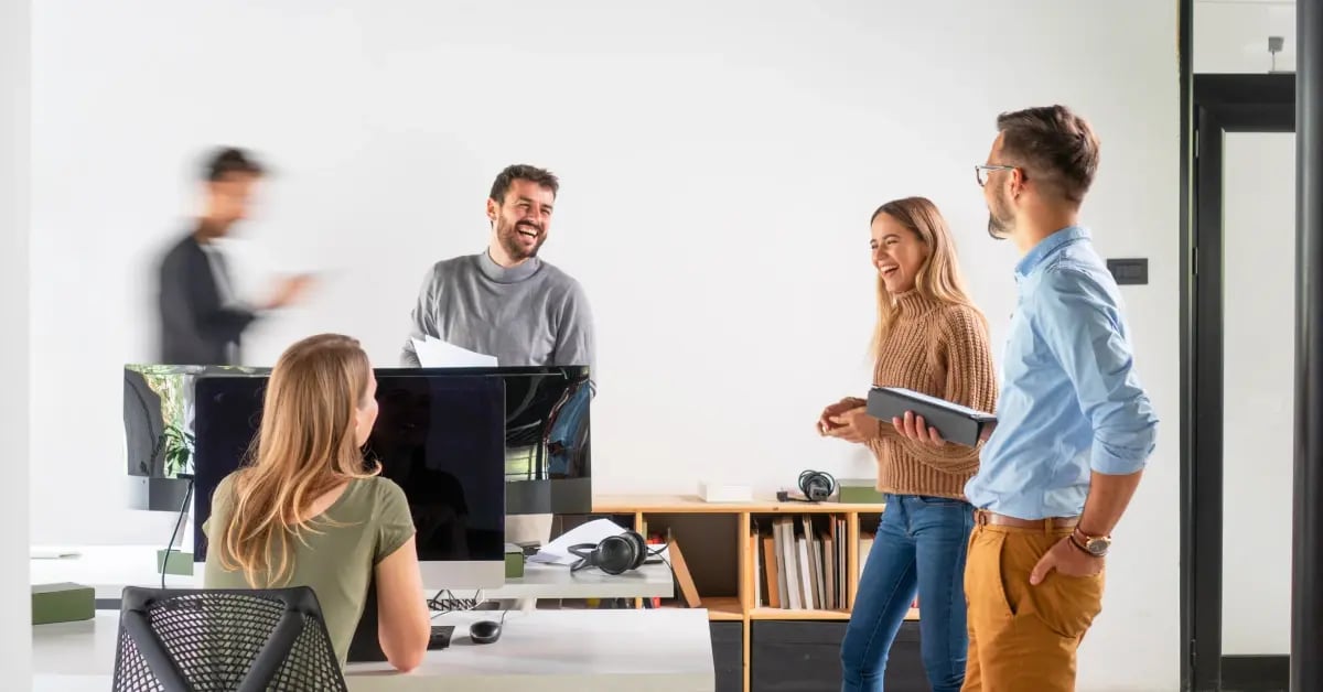 Team at the office laughing and talking about communication skills