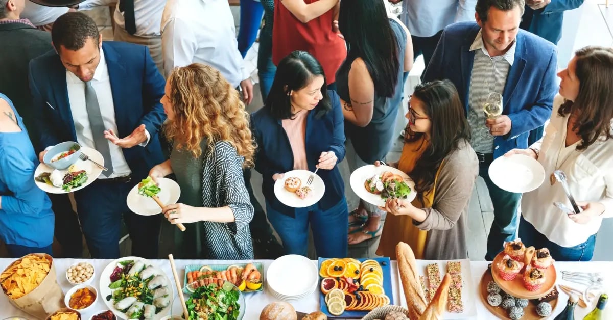Team standing and chatting at the buffet table while gathering food