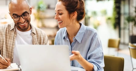 Two meeting planners discussing the best coworking meeting space brand for an upcoming in-person meeting.