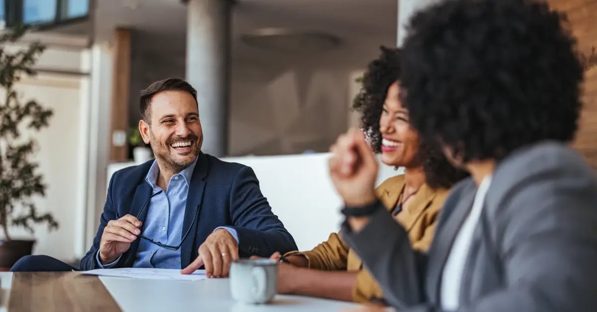 Male and female colleagues sitting at a table after a successful communication strategy meeting